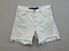 "1990's, Levi's, denim cut-off shorts in white.  There is no size labeled (Men's), so please refer to measurements for accurate sizing.  100% cotton.  Button waist with zip fly.  There are marks and they are very worn, see pictures. 17\" across waist 20.5\" across hips 12.25\" front rise 16.25\" back rise 6\" inseam 12\" across cuff" White 90s Style Shorts For Summer, White 90s Style Summer Shorts, White Cotton Jean Shorts With Frayed Hem, Distressed White Cotton Bottoms, White High-waisted Denim Jean Shorts, White Cotton Jean Shorts For Summer, Vintage White Bottoms For Summer, Vintage White Summer Bottoms, White Distressed Cutoff Bottoms