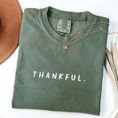 Celebrate gratitude in style with our Comfort Colors® "Thankful" shirt. Featuring a minimalist design, this tee is perfect for those who appreciate the beauty of simplicity and the power of a thankful heart. Whether for Thanksgiving, a casual day out, or a daily reminder of your blessings, this shirt will keep you feeling cozy and inspired. ✨ Features: Premium Comfort Colors® Fabric: Known for its ultra-soft, lived-in feel, this 100% ring-spun cotton shirt offers ultimate comfort and durability. Minimalist Design: The simple "Thankful" text creates a subtle yet powerful statement of gratitude. Perfect for All Occasions: Great for fall gatherings, Thanksgiving celebrations, or everyday wear as a reminder to be thankful. Unisex Fit: Available in multiple sizes and colors, perfect for men and Thanksgiving Shirts For Women, Grateful Shirt, Thankful Shirt, Plus Size Shirt, Thankful Heart, Thanksgiving Celebration, Be Thankful, Fall Shirt, Thanksgiving Shirts