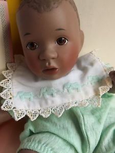 a baby doll is wearing a green dress