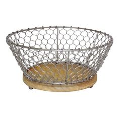 a metal wire basket sitting on top of a wooden base