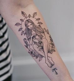 a woman's arm with an arrow and flower tattoo design on the left forearm