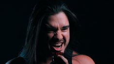 a man with long hair holding a toothbrush in his mouth and yelling into the camera