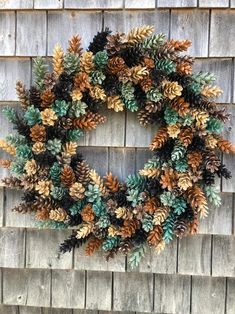 a wreath made out of pine cones on a wooden wall