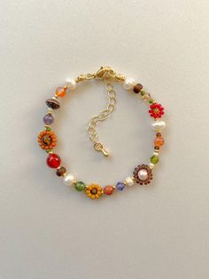 Armbandlengte: 6 inch Elke armband heeft een 2 inch 14k gold filled verlengstuk Deze ketting is voorzien van crème, rood, oranje, mosterd, mat transparant bruin en 24-karaats vergulde rocailles. Het bevat ook crèmekleurige, groene, paarse kristallen kralen. Naast zoetwaterparels, amethist, Fall Beaded Jewelry, Bead Bracelet Patterns, Bracelet Flowers, Arm Candy Bracelets, Fall Bead, Carnelian Bracelet, Fall Flower, Bracelet Diy, Jewelry Beads