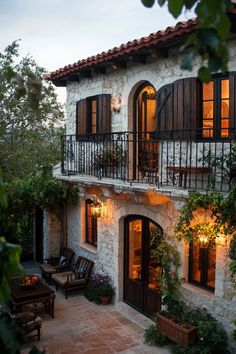 Charming stone cottage with a balcony and warm lights. Embark on a whirlwind tour of luxurious abodes where opulence meets whimsy, leaving you green with envy and ideas for your next home upgrade.