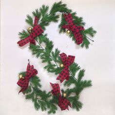 a christmas wreath with red and black plaid bows