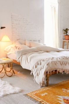 a bedroom with white brick walls and an orange rug on the floor next to a bed