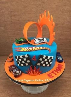 a birthday cake decorated with cars and flames