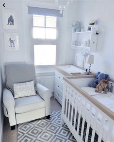 a baby's room with a crib, chair and window