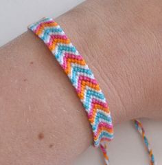 a person wearing a colorful bracelet on their arm