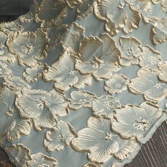 the fabric has gold flowers on it and is light blue with gold trimmings