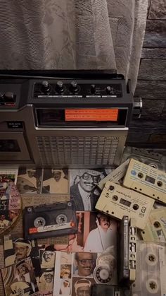 an old radio sitting on top of a table covered in cassette tapes and other items