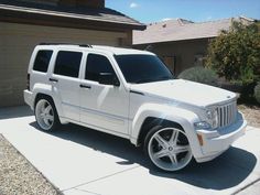 a white jeep parked in front of a house