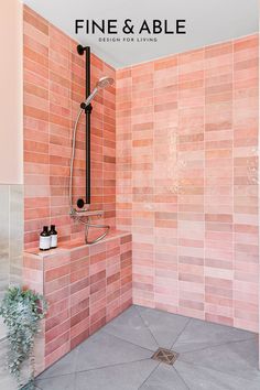 a bathroom with pink tiles on the walls and floor, including a bathtub that has a shower head