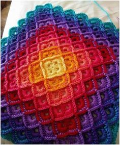 a crochet baby blanket is shown in bright colors