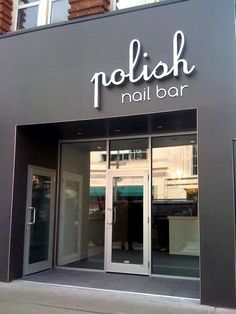 a nail bar sign on the side of a building with glass doors and windows that say nolish