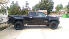 a black truck parked in front of a house