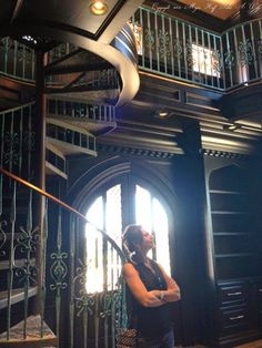 a woman standing in front of a spiral staircase