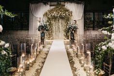 the aisle is decorated with flowers and candles