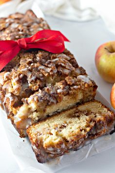 a loaf of cinnamon apple bread on top of a white plate next to two apples