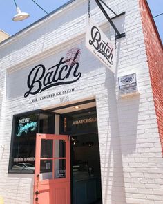 the exterior of a restaurant called batch, with an orange door and brick wall