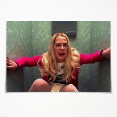 a woman sitting on top of a toilet in a bathroom next to a green wall