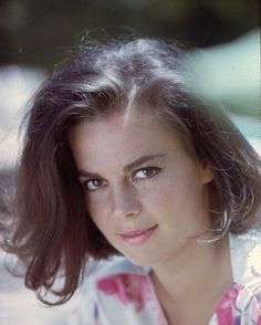 an old photo of a woman with brown hair and blue eyes looking at the camera