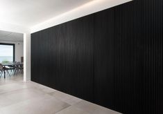 an empty room with black and white striped wall covering the entire wall, along with a dining table and chairs