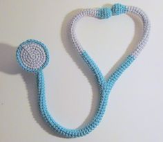 a blue and white crocheted necklace with a stethoscope on it