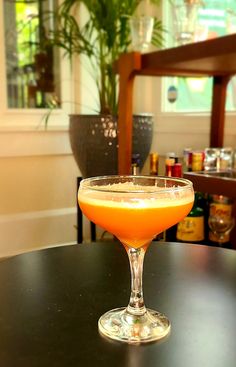 an orange drink sitting on top of a table