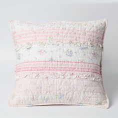 a white pillow with pink and blue flowers on it