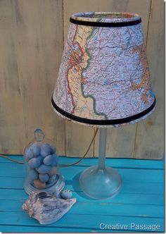 a lamp that is sitting on top of a blue table next to a glass vase