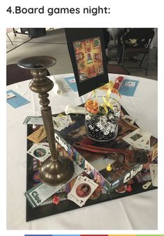 a table topped with pictures and a candle on top of a white cloth covered table