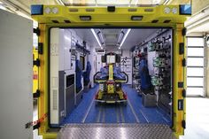 the inside of a yellow and blue vehicle with equipment in it's back door