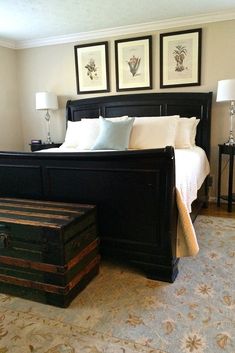 a bedroom with a bed, chest and two pictures on the wall above it's headboard