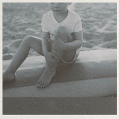 a young boy sitting on the edge of a boat