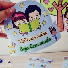 someone holding up a sticker with two children reading books