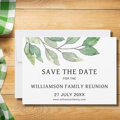 save the date card with watercolor leaves on it and green checkered table cloth