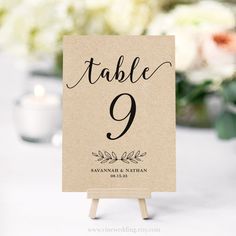 a table number sign sitting on top of a wooden easer