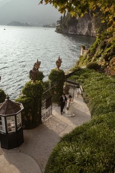 the bride and groom are walking down the stairs by the water