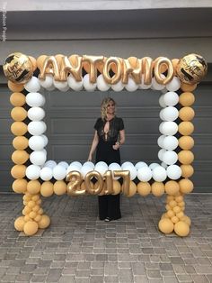 a woman standing in front of a balloon arch