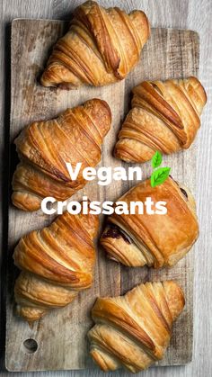 several croissants on a cutting board with the words vegan in white lettering