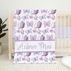 a baby crib with a purple and white blanket on it that says,'aubree mae '