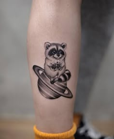 a small raccoon tattoo on the leg