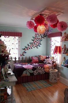 a bedroom decorated in pink and purple with lots of decorations on the ceiling, windows, and bed