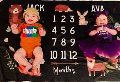 two babies laying on top of a blanket with numbers and animals printed on the back