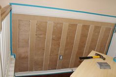 a room that is being remodeled with wood paneling on the wall and tools in front of it