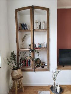 a living room filled with furniture next to a wall mounted tv and bookshelf