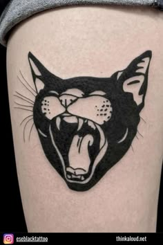 a black and white cat tattoo design on the side of a woman's thigh