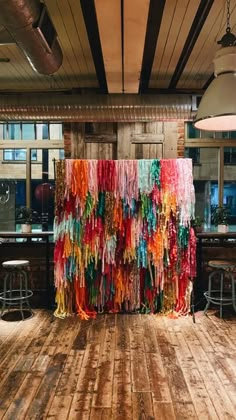 a room with wooden floors and walls decorated with colorful streamers hanging from the ceiling